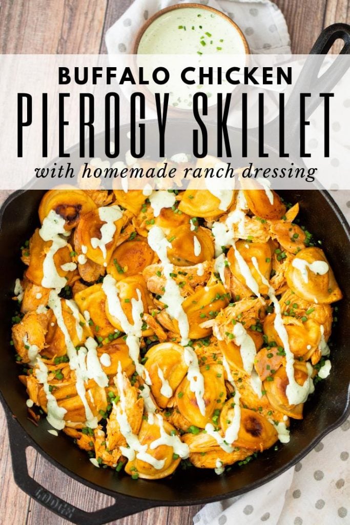 buffalo chicken pierogies in a cast iron skillet with a bowl of ranch dressing on the side.