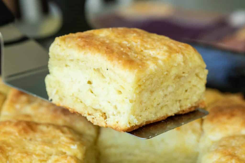 close up picture of a baked buttermilk biscuit on a spatula.