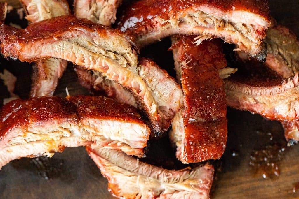 Overhead view of sliced smoked ribs, topped with maple bourbon glaze.