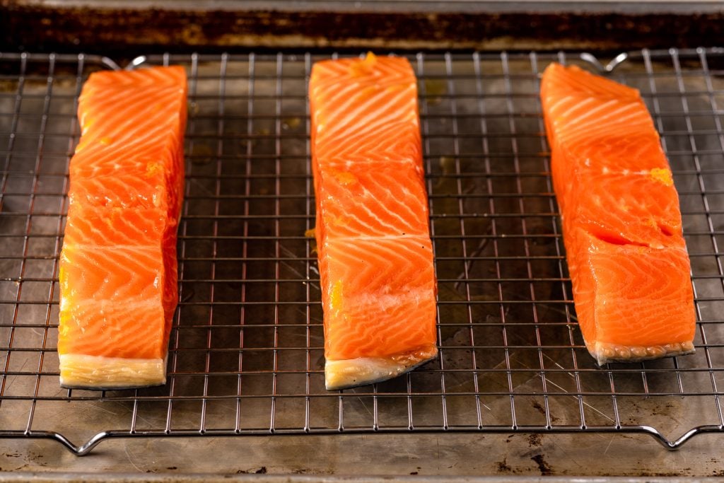 Salmon filets on the grill grates of a smoker.
