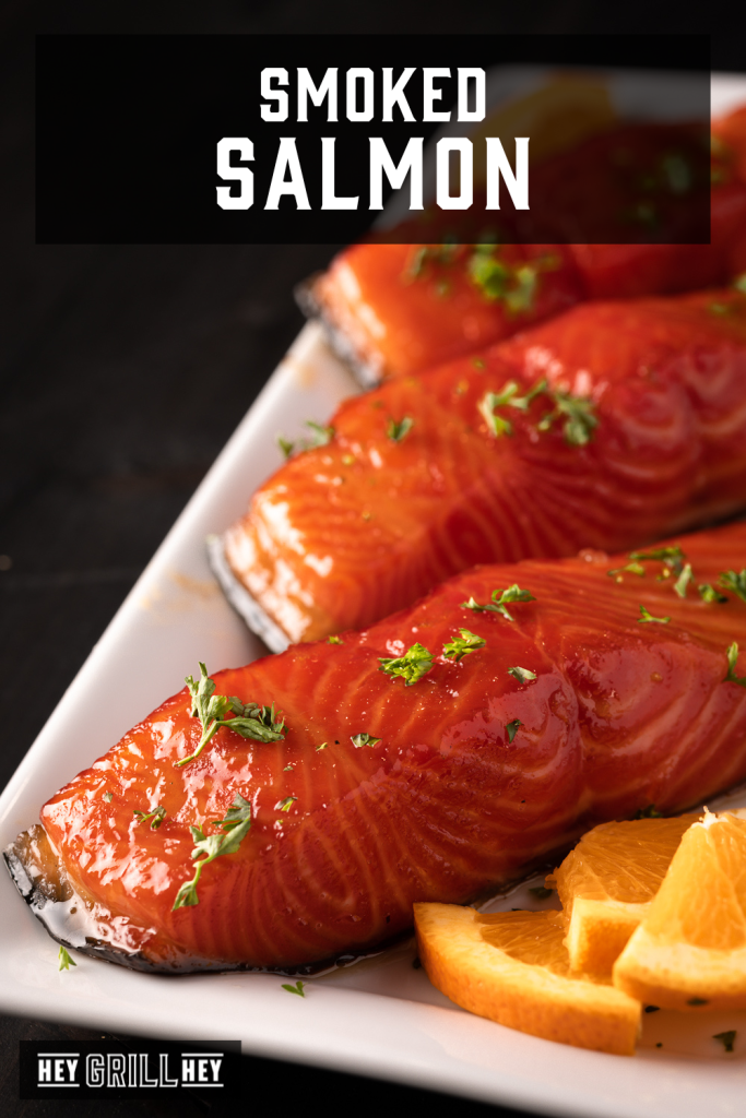 Three smoked salmon filets on a white serving dish with text overlay - Smoked Salmon.