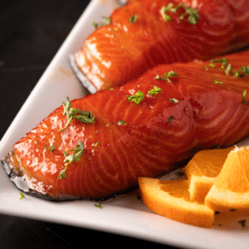 Two smoked salmon filets on a white serving dish.