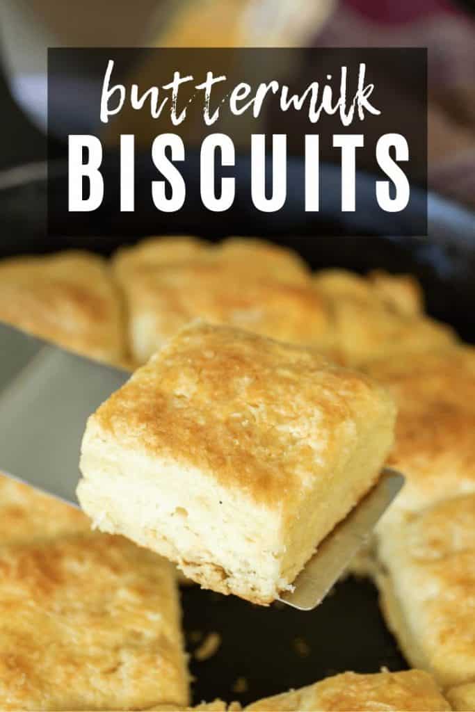 spatula lifting one buttermilk biscuit out of a pan with buttermilk biscuits text overlay.