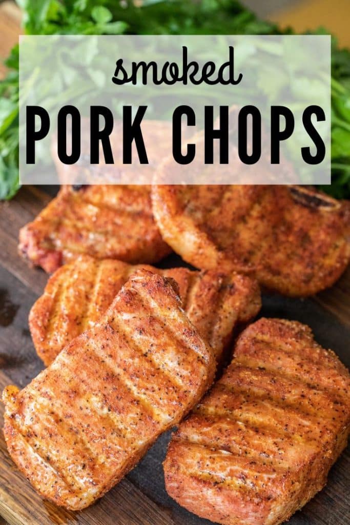 5 smoked pork chops on a wood cutting board with parsley. Text overlay reads "smoked pork chops."