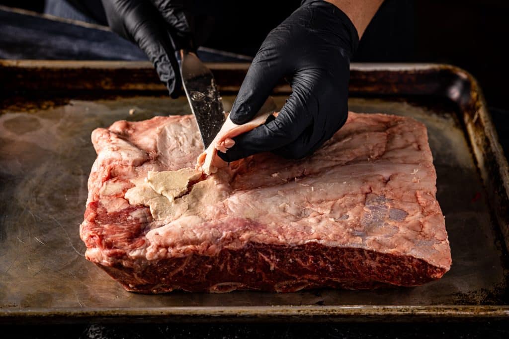 Beef rib membrane being pulled off the ribs.