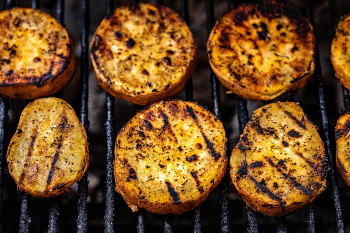 Sweet potato slices on grill grates.