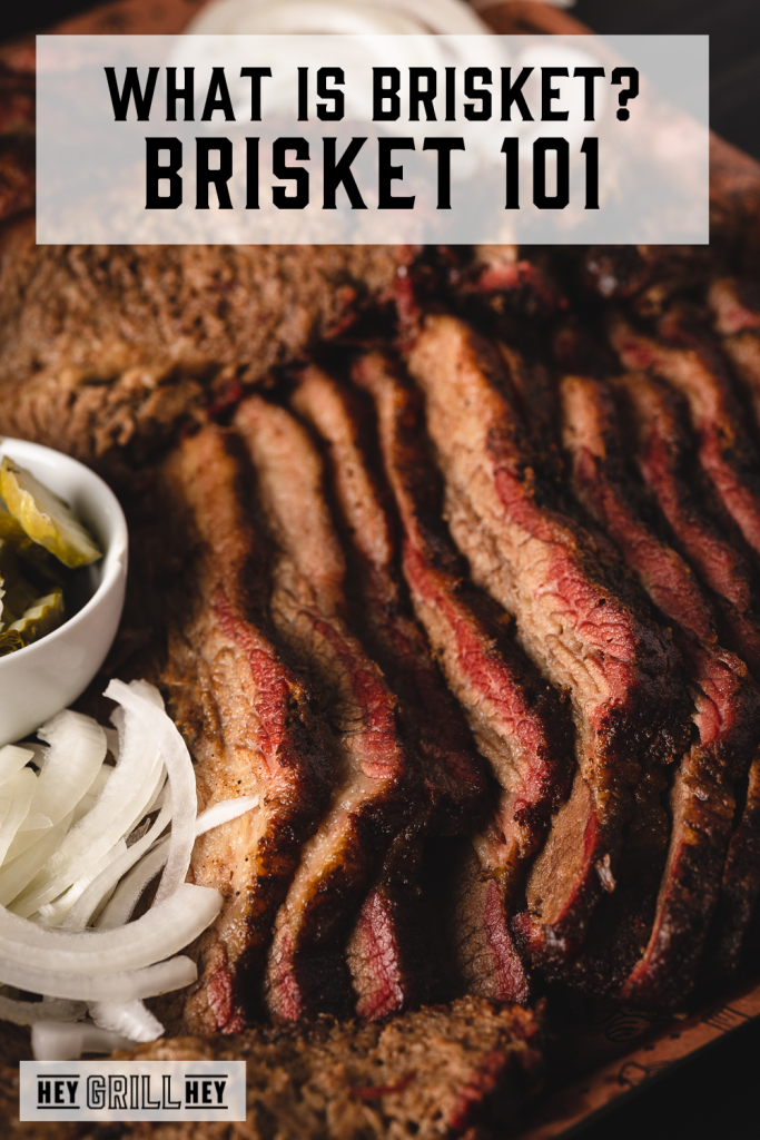 Sliced brisket next to onions and pickles with text overlay - What is Brisket? Brisket 101.