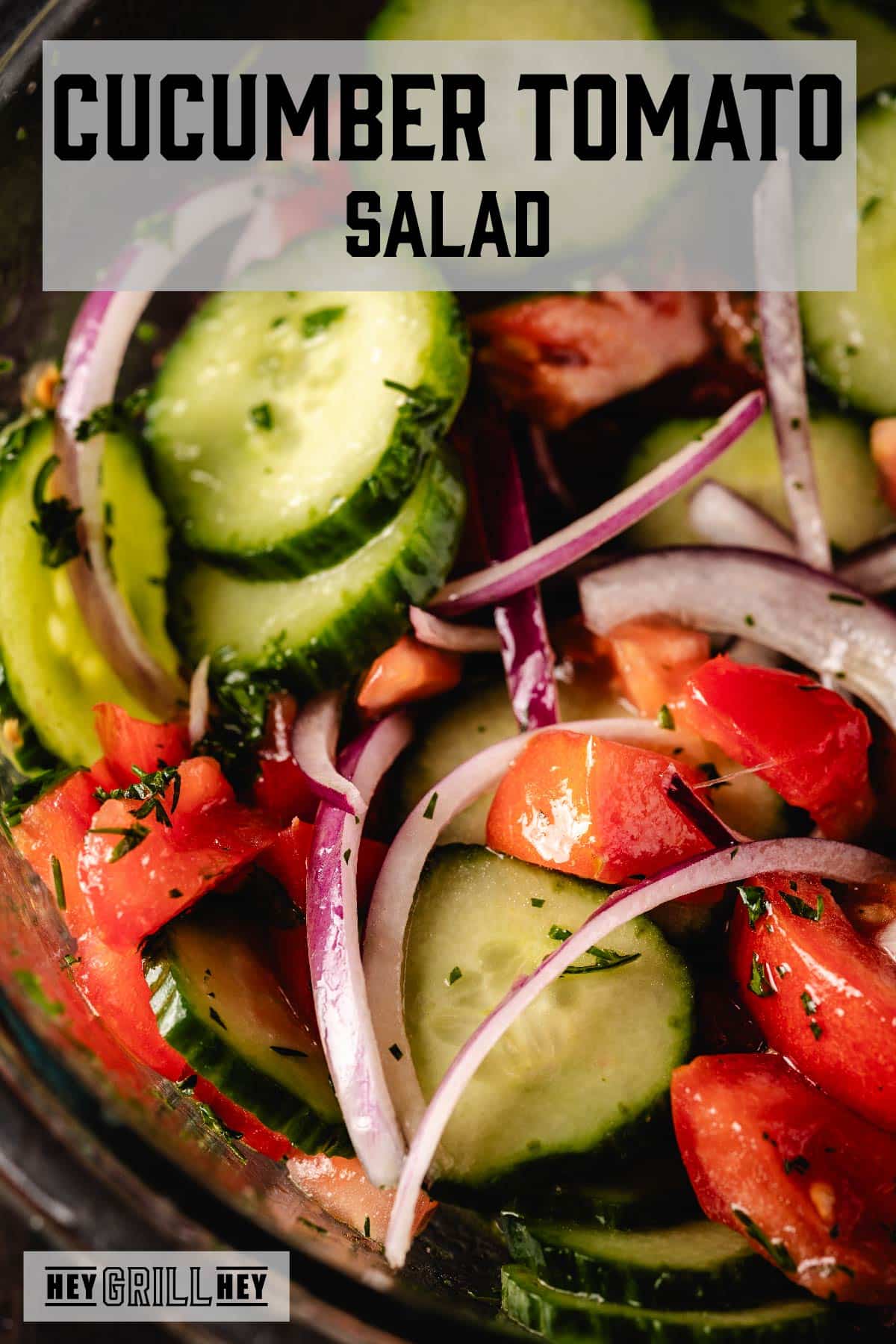 A close-up shot of a vegetable salad. The text overlay reads "Cucumber Tomato Salad" at the top, and "Hey Grill Hey" at the bottom.