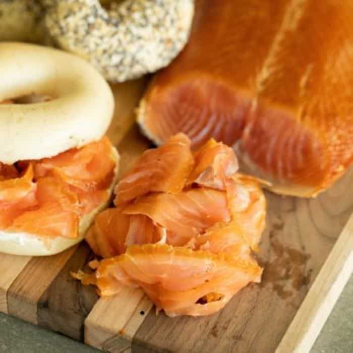 Smoked salmon meats on bagel and cutting board.