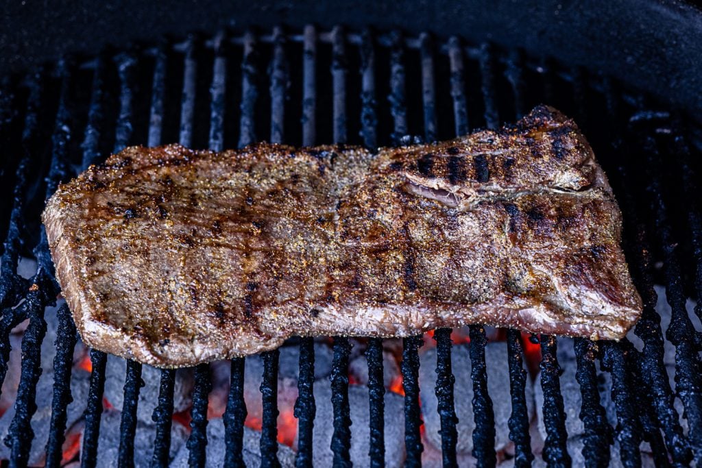 Seasoned flap steak on the grill.