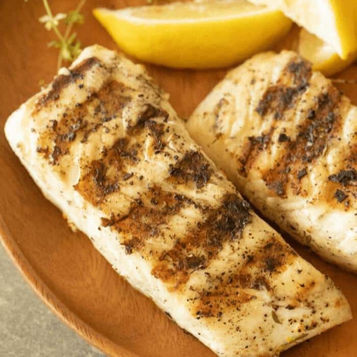 grilled halibut on a wooden plate