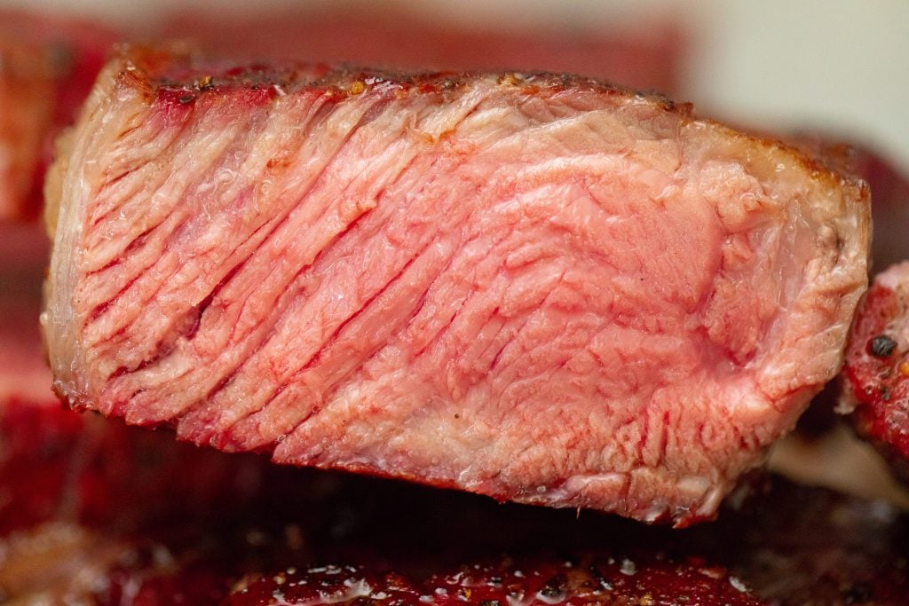 steak cooked to medium temperature, sliced open to show the inside of the steak.