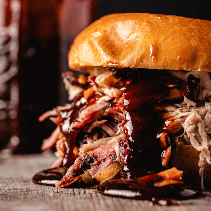 Pumpkin spice pulled pork on a bun with coleslaw and pumpkin spice bbq sauce.