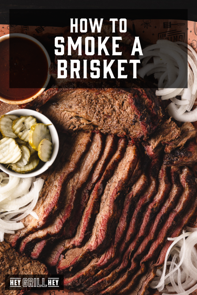 Smoked brisket on a platter with all the fixings with text overlay - How to Smoke a Brisket.