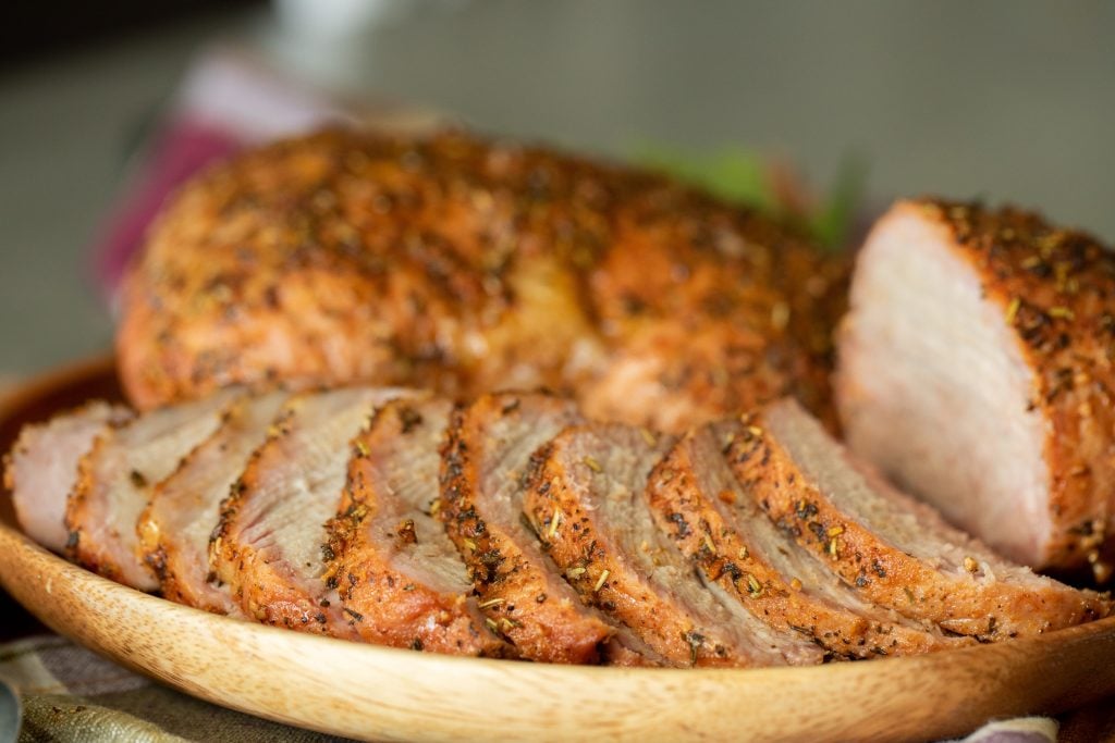 sliced smoked pork sirloin on a wooden plate.
