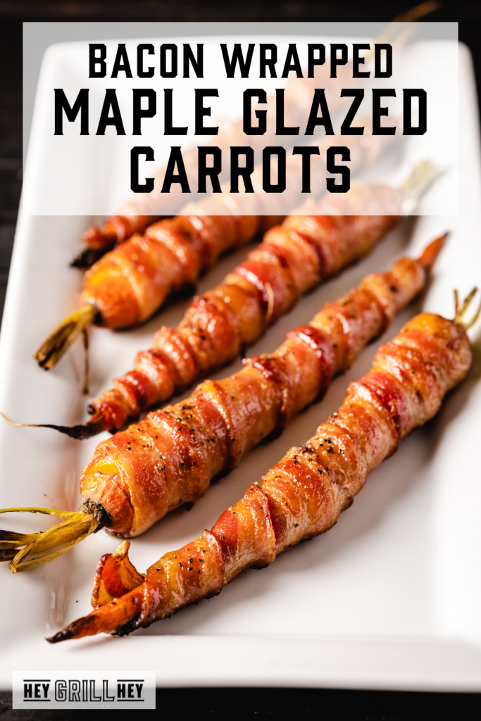 Bacon wrapped carrots on a white serving platter with text overlay - Bacon wrapped maple glazed carrots.