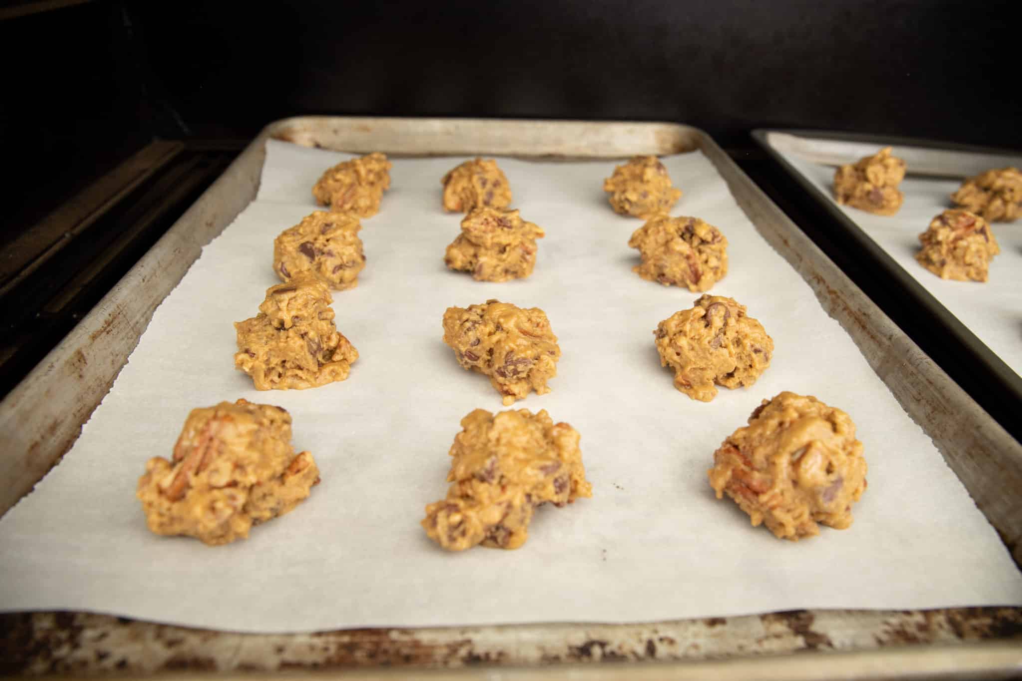 12 balls of smoked chocolate chip cookie dough batter on a baking sheet.