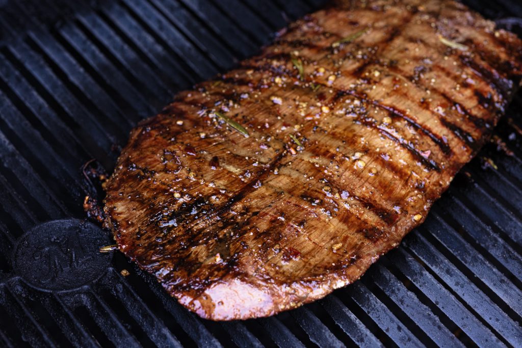 Marinated flank steak on the grill.
