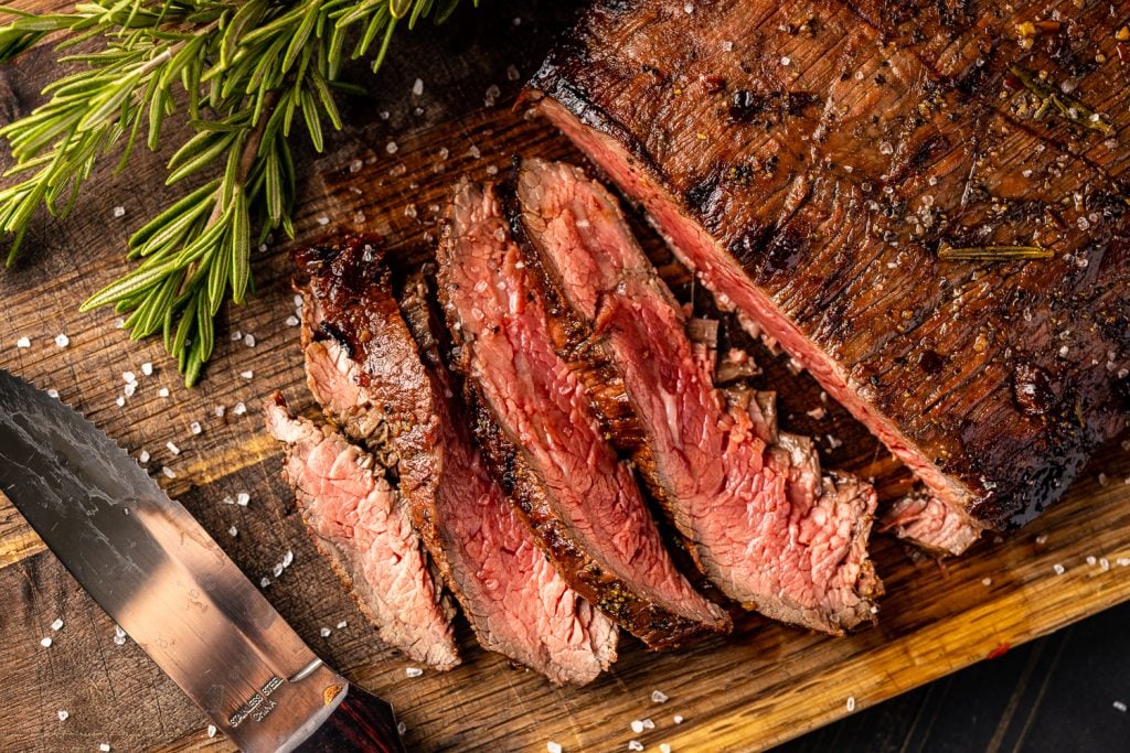Sliced flank steak on a cutting board.