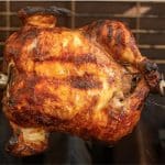 Buttermilk marinated chicken on a rotisserie in a gas grill.