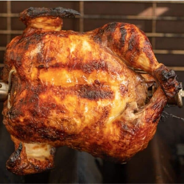 Buttermilk marinated chicken on a rotisserie in a gas grill.