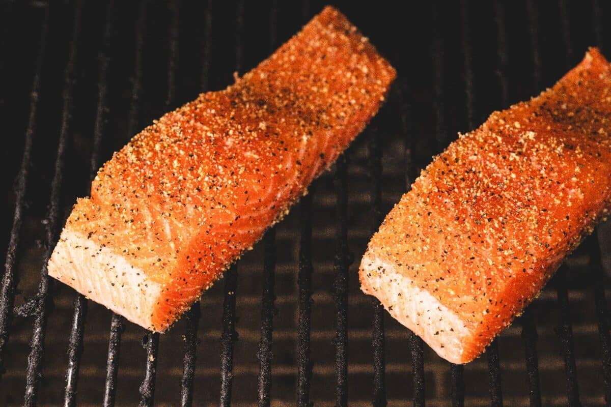 Salmon fillets on the grills of a smoker.