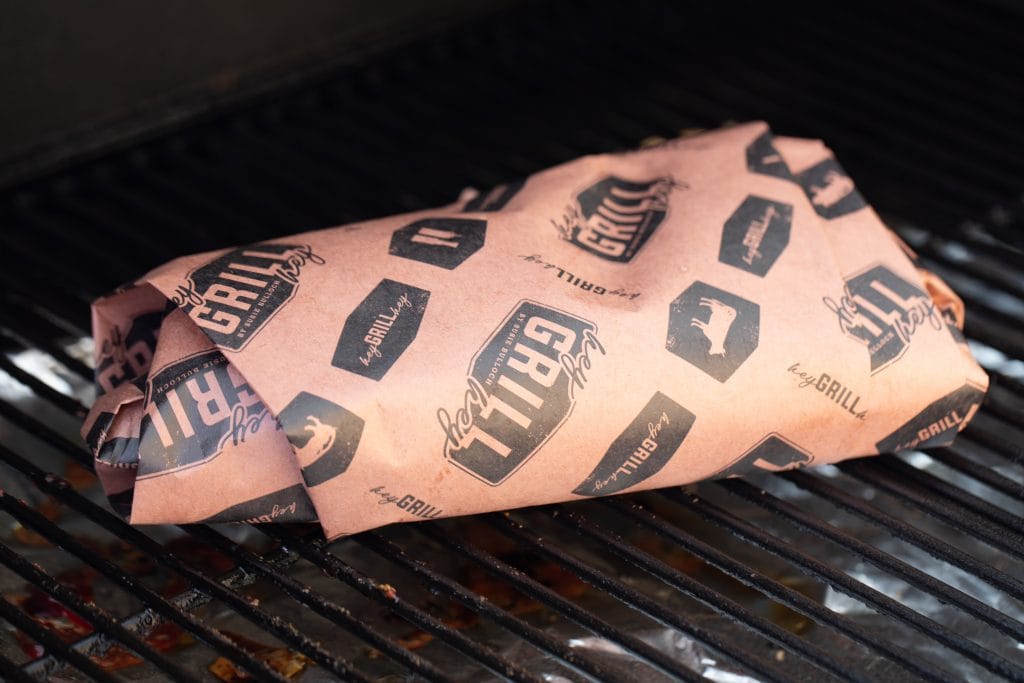 tri tip wrapped in Hey Grill Hey branded peach butcher paper on the smoker