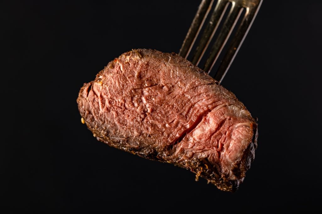 Medium Well steak on a fork.
