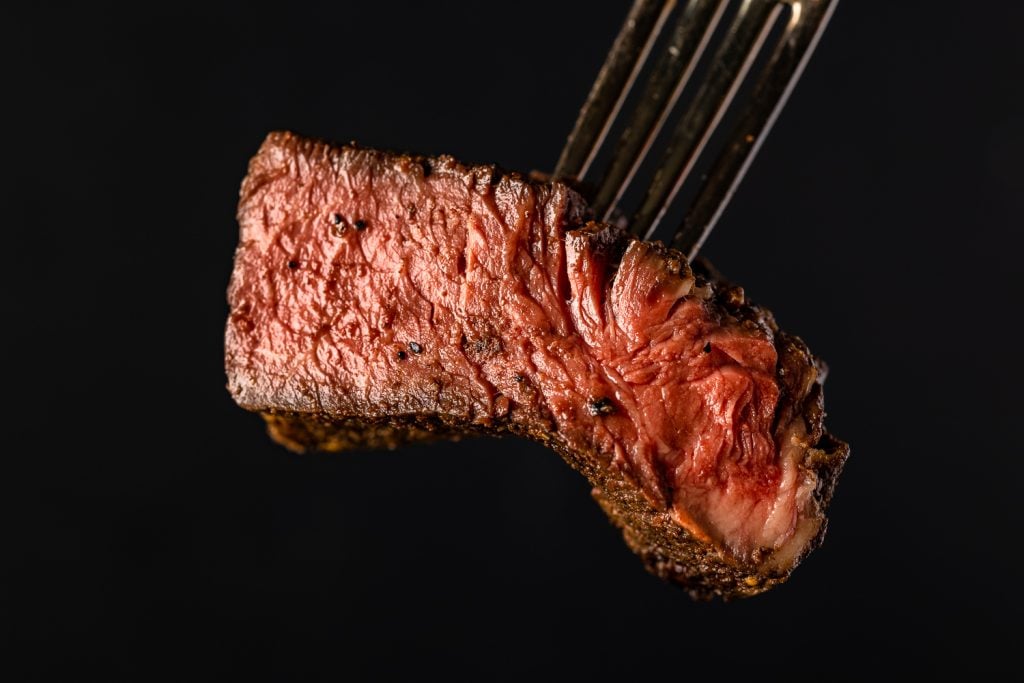Medium steak on a fork.