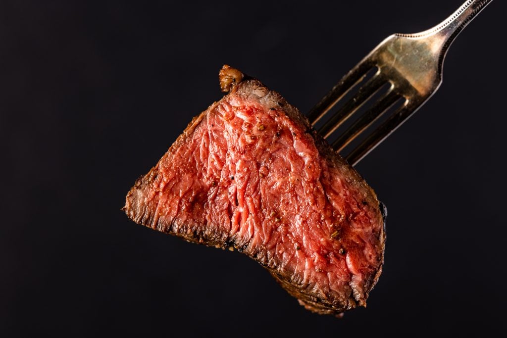 Rare steak on a fork.