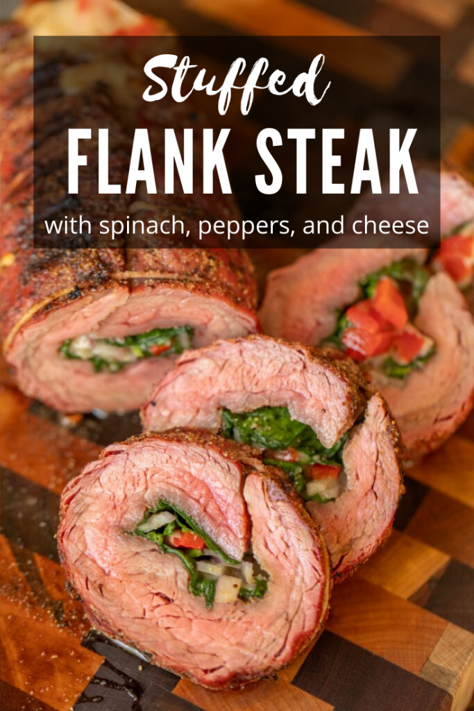 Medium Rare flank steak stuffed with spinach, peppers, and cheese. Four sliced laying in a diagonal to display interior stuffing and arranged on a mixed wood cutting board.