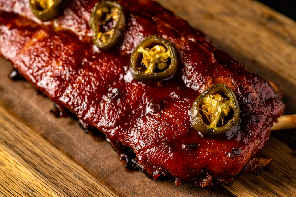 Rack of apple jalapeno ribs on a wooden cutting board.