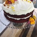 Red Velvet Cake with Ermine Frosting and Fresh Flowers. on a wooden table.