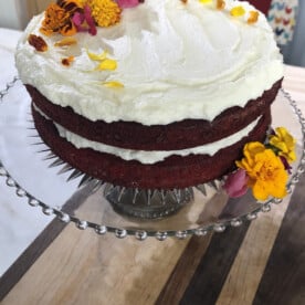 Red Velvet Cake with Ermine Frosting and Fresh Flowers. on a wooden table.