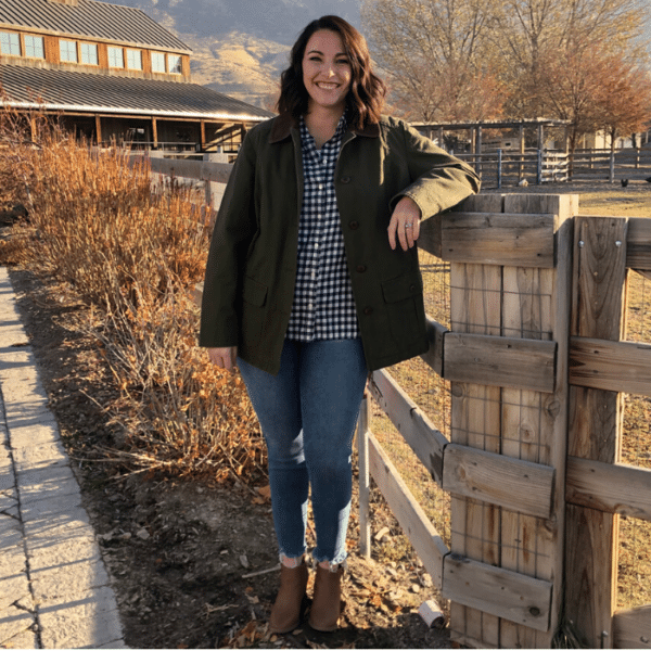Susie leans against a wooden rail on a farm in Lehi, Utah.