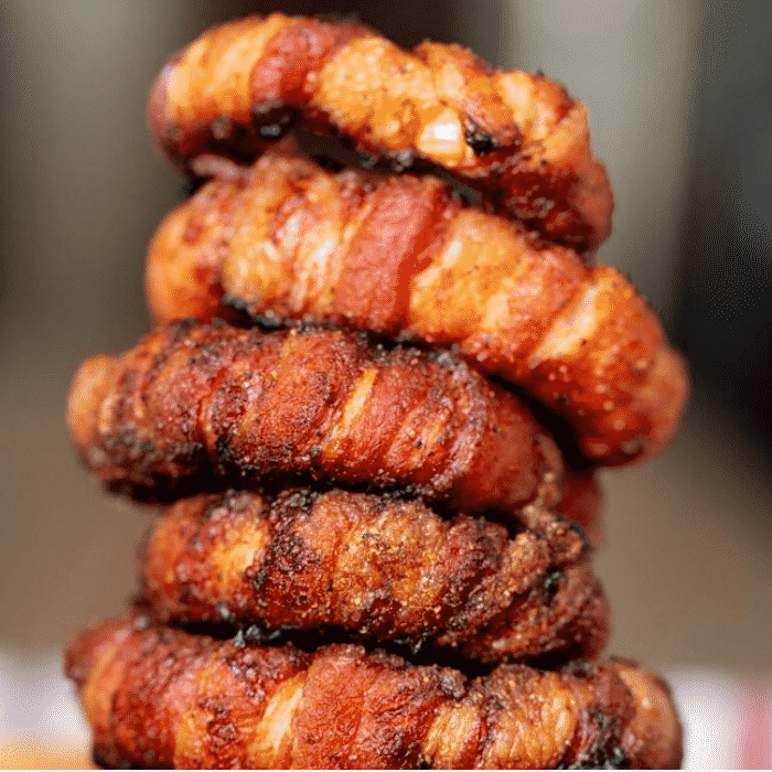 Five stacked bacon wrapped onion rings.