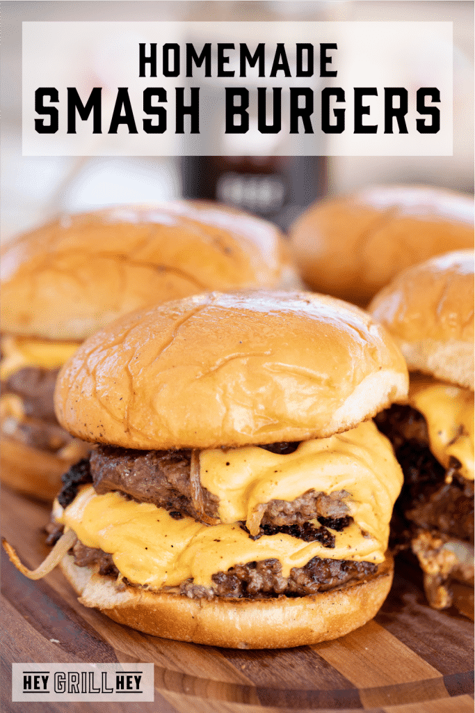 Smash burgers on a wooden cutting board with text overlay - Homemade Smash Burgers.