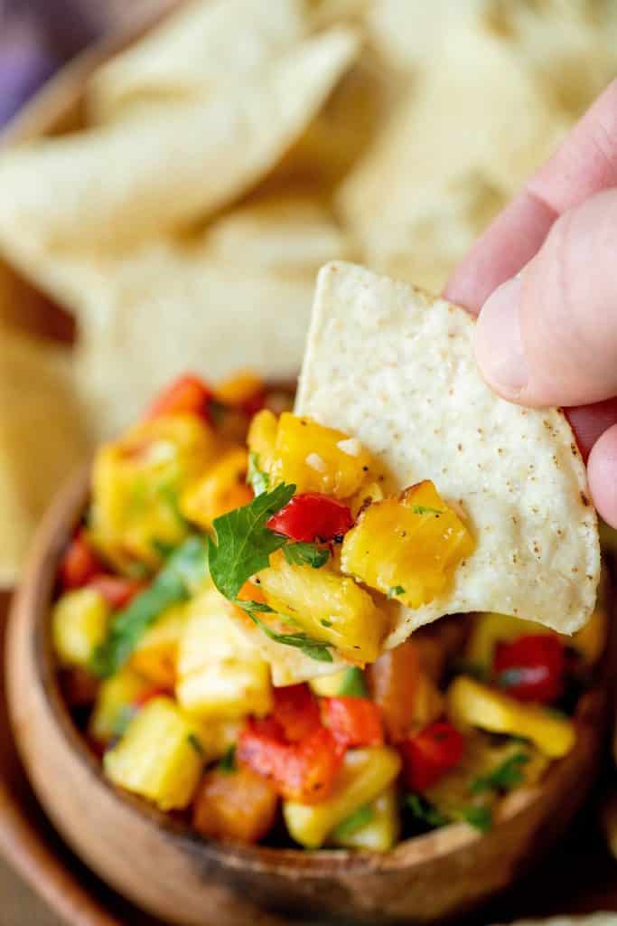 Grilled pineapple salsa on a white corn chip.