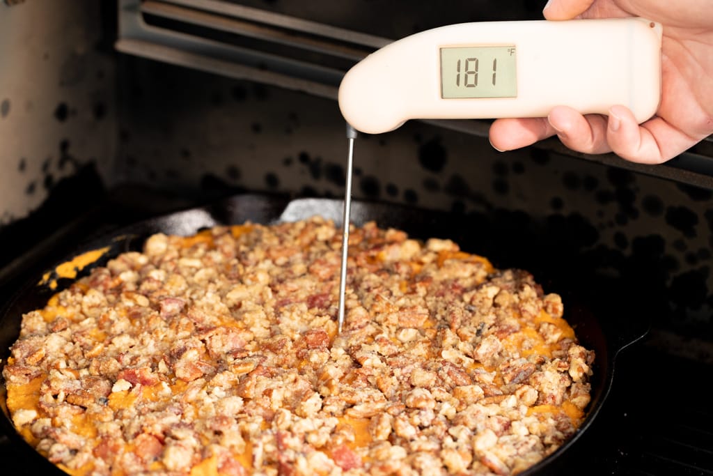 Peach colored instant read thermometer stuck in a sweet potato casserole reading 181 degrees F.