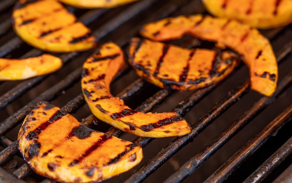 Sliced butternut squash with grill marks, while still on the grill.