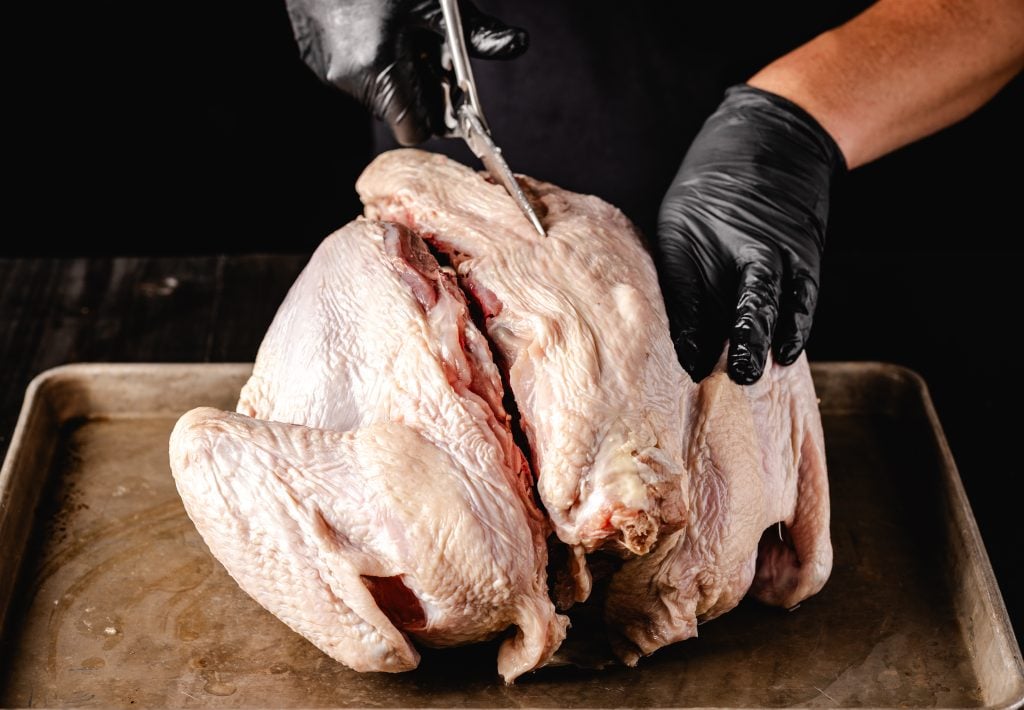 Backbone being cut out from a turkey.