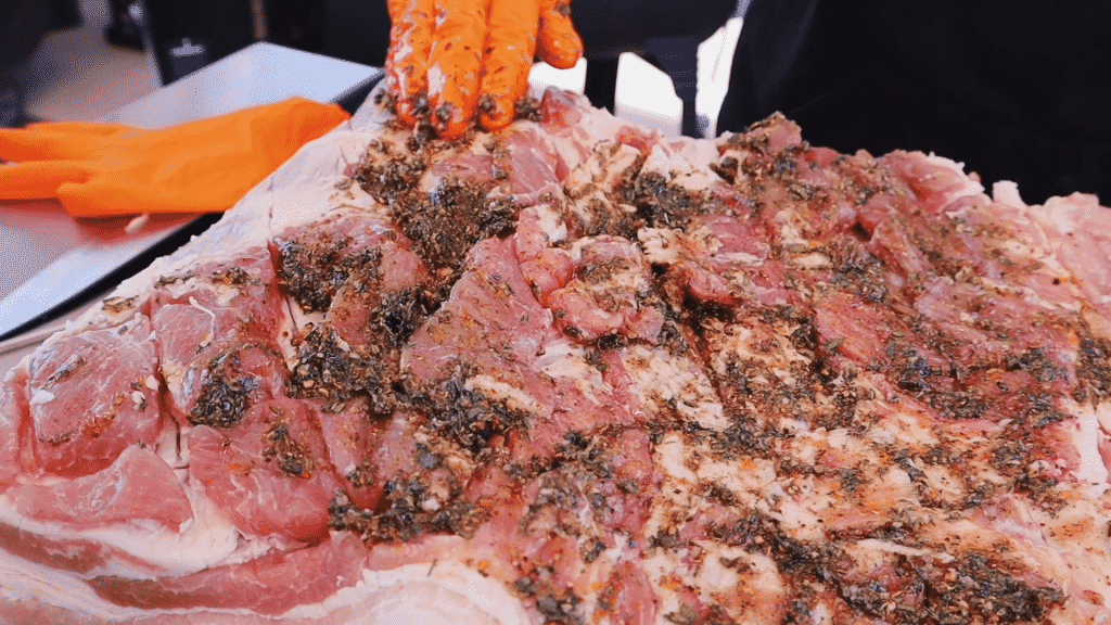 Porchetta seasoning spread on scored pork loin.
