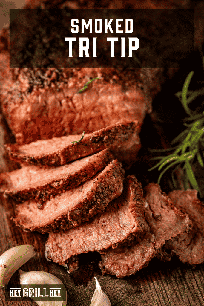 Sliced smoked tri tip on a wooden cutting board with text overlay - Smoked Tri Tip.