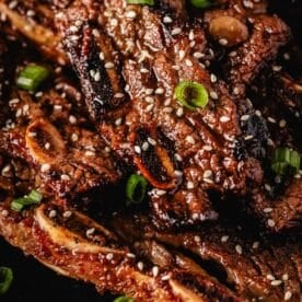 Kalbi ribs topped with sesame seeds and green onions.