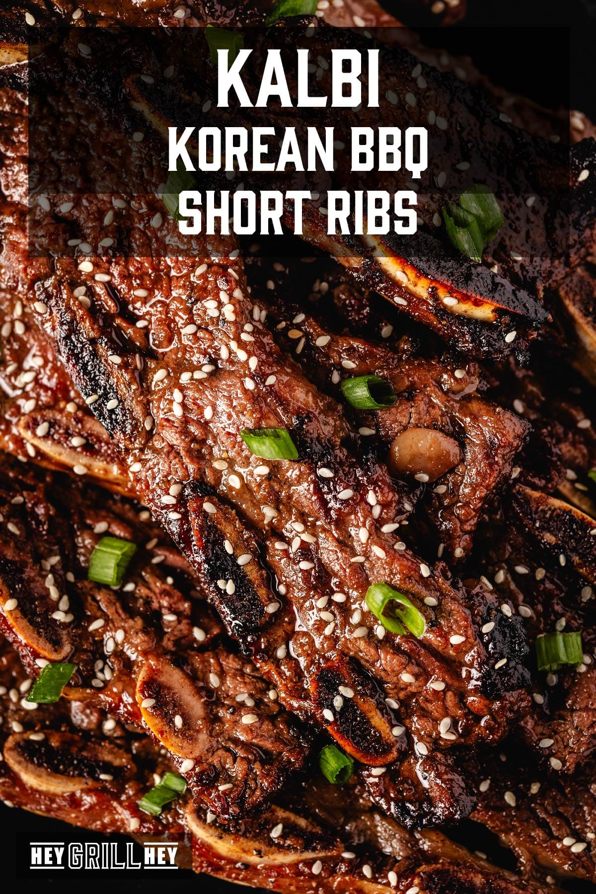 BBQ short ribs with sesame seeds and green onions. Text reads "Kalbi Korean BBQ Short Ribs".