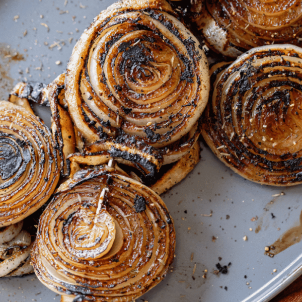 Grilled onion slices on a metal baking dish.