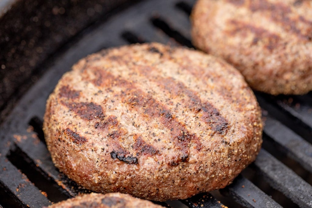 Juicy Lucy burger on the grill will visible grill marks