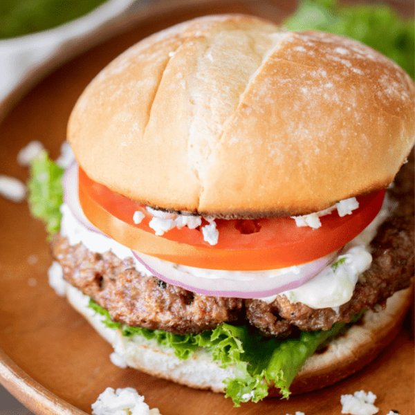Lamb Burger topped with tomato, onion, lettuce, and feta cheese.