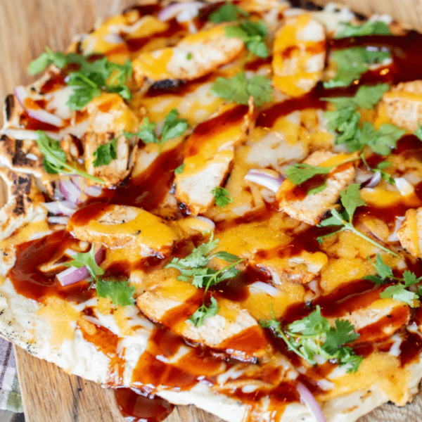 BBQ chicken pizza topped with BBQ sauce, chicken, cheese, and cilantro.