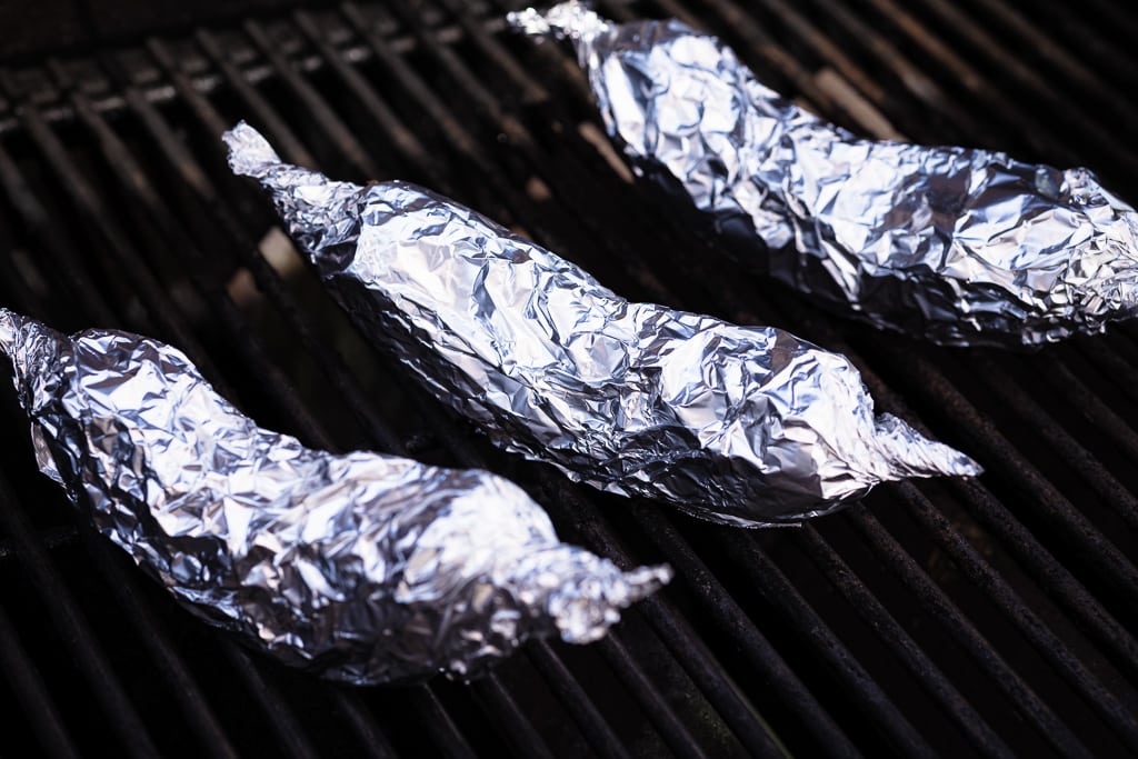 Bananas wrapped in aluminum foil on the grill.